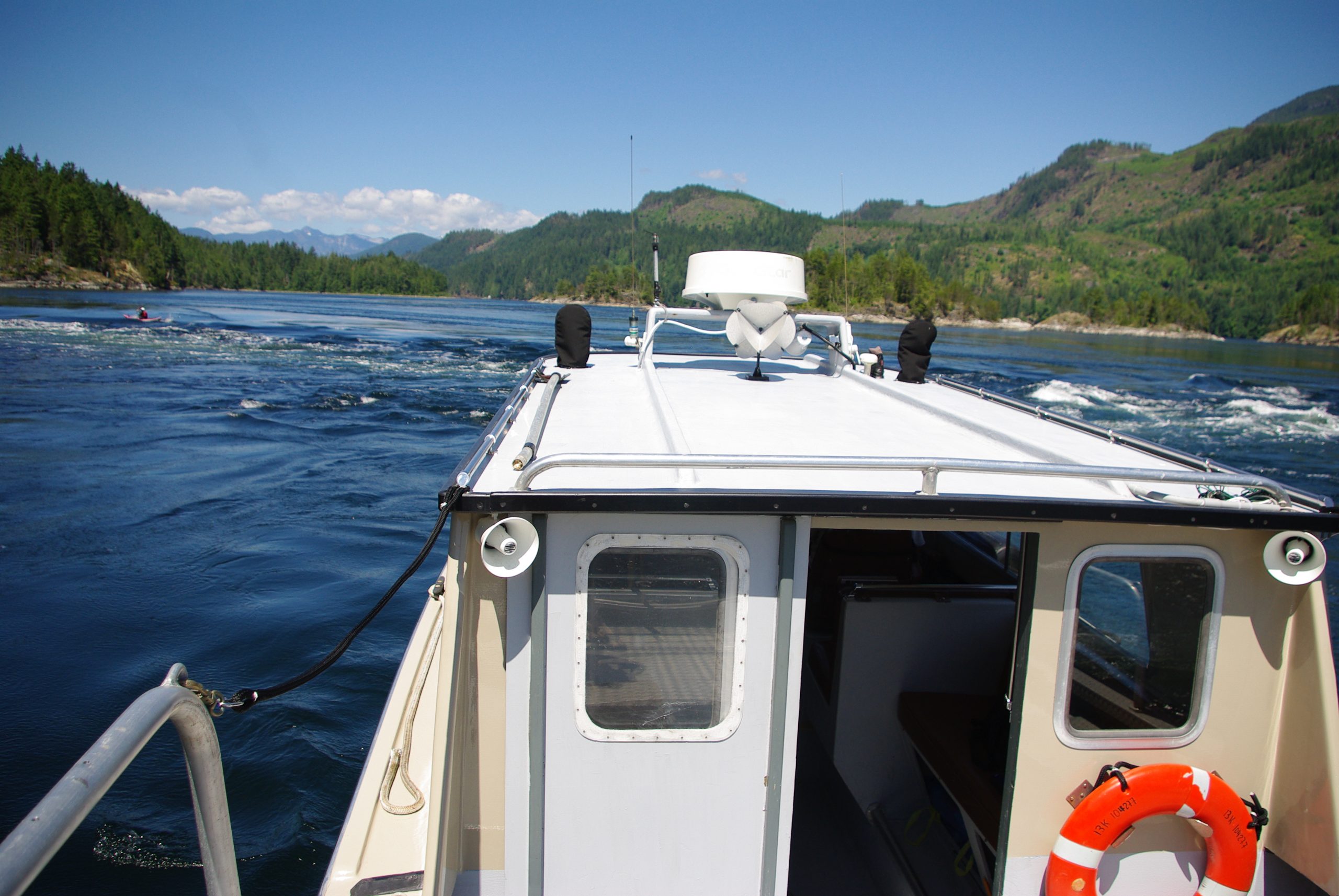 Tour boat watching kayaker in Sechelt Rapids